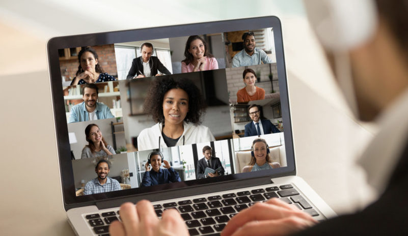 Young businessman holding working video call with diverse colleagues.